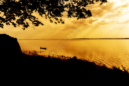 一只独自的渔民在小船上湖走出去太阳破晓夜晚背景图片