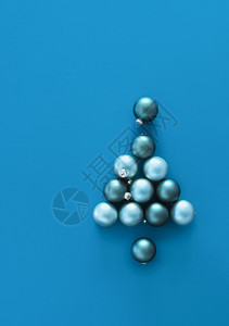 蓝色背景的圣诞树形状在从Xmas球的蓝色圣诞树上看到蓝色的圣诞树传统的装饰框架背景图片