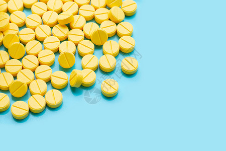 蓝色背景上黄的扑热氨醇药片高清图片