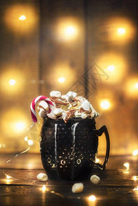 含棉花糖和奶油的热可黑杯子和绳灯木质背景圣诞节灯光和热饮图片