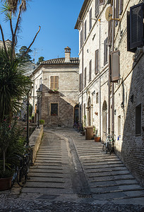 在意大利小街上的旧建筑在意大利小街的狭窄道上在古老房屋前的鲜花背景图片