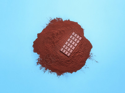 在蓝底的可粉堆上加巧克力棒在可粉堆上加奶巧克力方块在圣诞节做饭时加糖图片