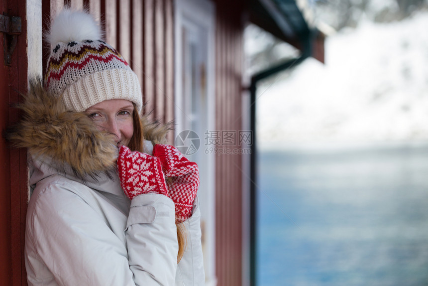 快乐的挪威女孩用红手套给摄像头装上挪威式的红手套图片