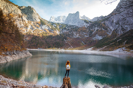 背包的女孩站在湖岸边图片