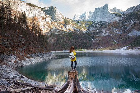 背包女孩站在山湖岸边高清图片