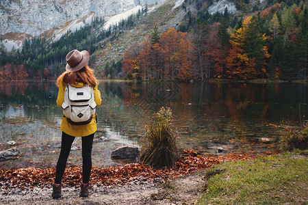 背包女孩站在山湖岸边图片