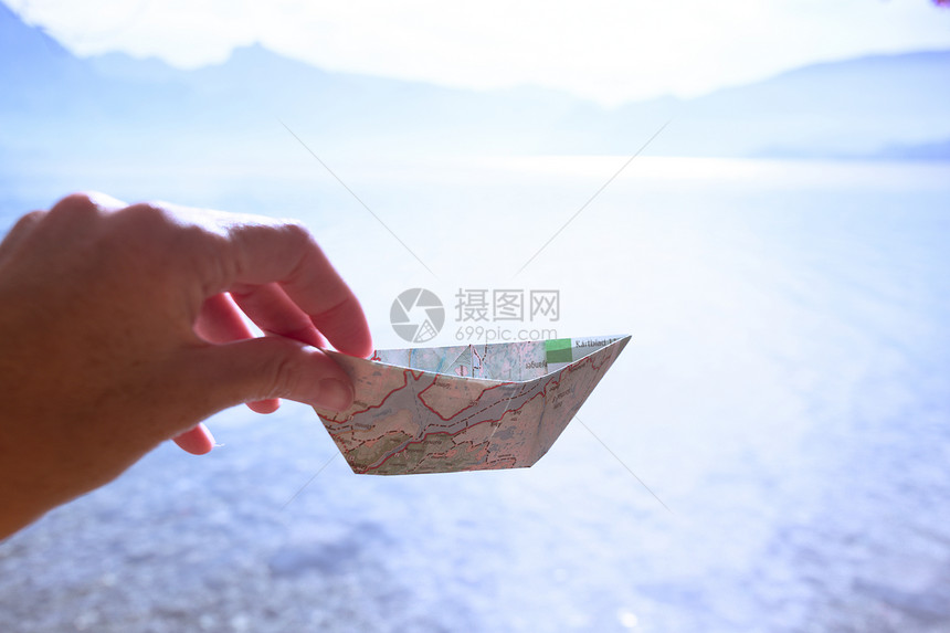 女孩在湖底夏季和旅行中持有一张上的纸船图片