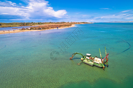 dreg船挖沙在Croati的dlmti地区宁镇附近的浅水沙滩上背景图片