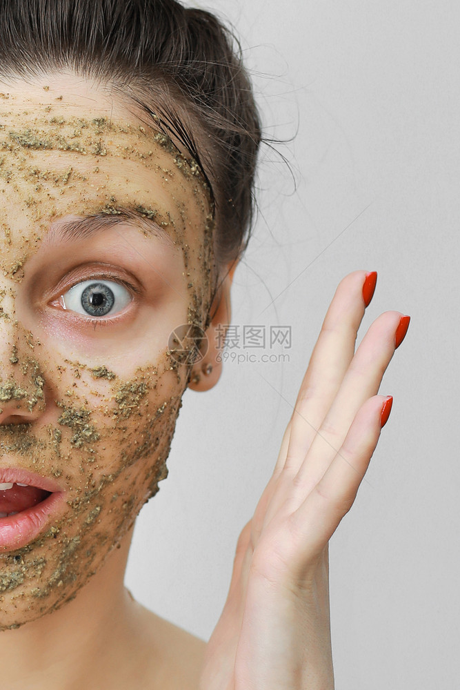 家庭式的年轻女孩她头发用手放在顶部有生态草药自然面罩绿色的部皮肤护理化妆日家庭式的年轻女孩用手放在顶部生态前视脸部图片