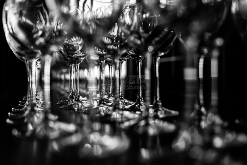 从玻璃摊上甚至连排的玻璃摊上红酒杯空有选择焦点美丽玻璃杯在餐馆的木桌上连排玻璃摊红酒杯图片