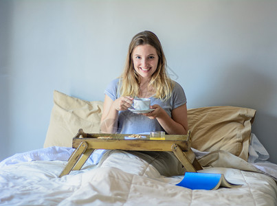 女孩在床上吃早餐和喝咖啡图片
