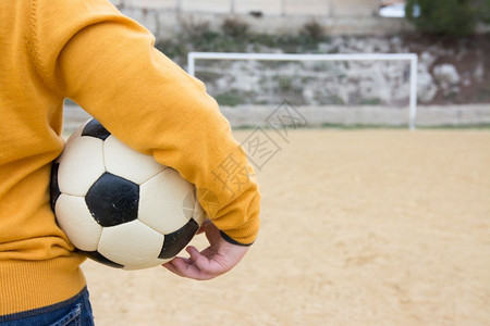 男孩在足球场抱着足球图片