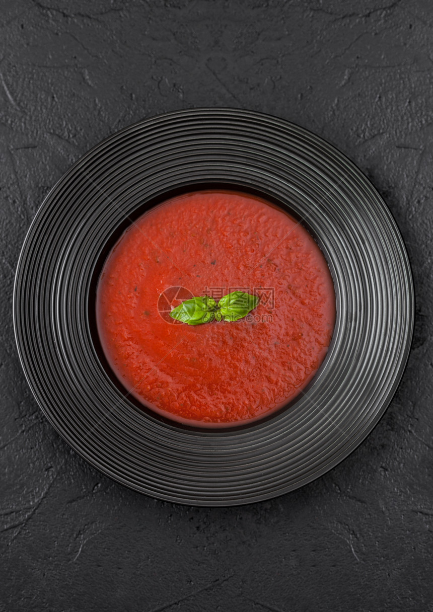 黑餐厅盘上背景的奶油番茄汤最高视图图片
