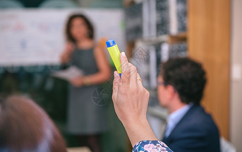 商业会议上一位女商人用高光笔举手提问女商人举手提问图片