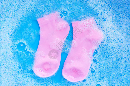 中袜子素材粉色袜子浸泡在清洁水溶解中洗衣概念顶层视图背景