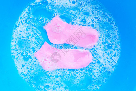 粉色袜子浸泡在末洗涤水溶解中衣服的概念图片