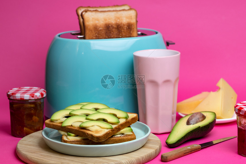 亮的有趣早餐粉红背景的青色烤面包机图片