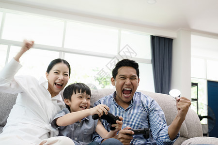 父母带着儿子在客厅看电视玩游戏图片