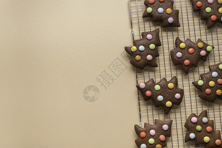 以树形装饰的圣诞饼干在冷却架上黄色背景巧克力姜饼干在树形上图片