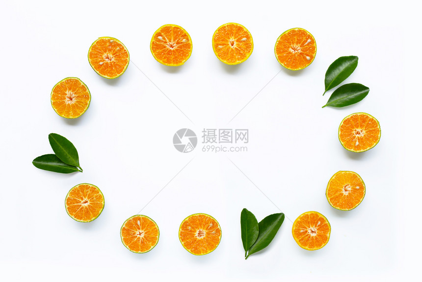 由新鲜橙子和白色背景绿叶子制成的框架复制空格图片