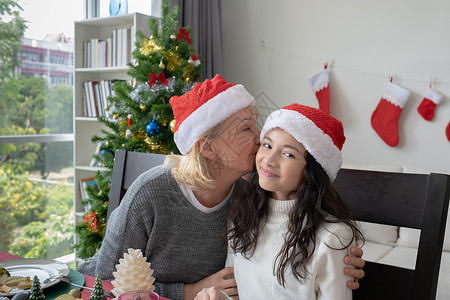 欢乐家庭肖像祖母微笑和亲吻女儿并一起庆祝圣诞节日图片