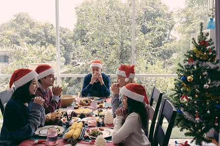 家人在圣诞节吃饭前祈祷他们快乐并一起吃饭图片