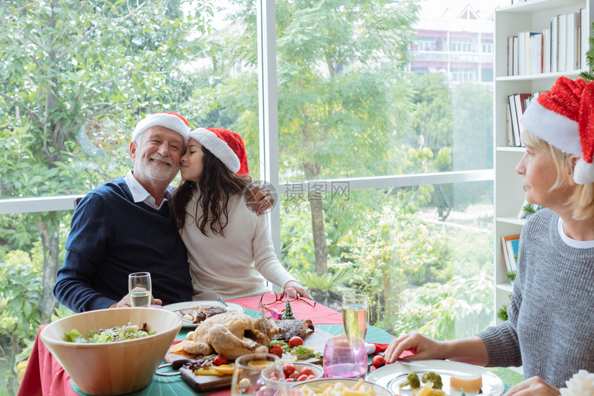快乐的家庭爷微笑和拥抱女儿的小孩并一起庆祝圣诞节在餐厅的圣诞节图片