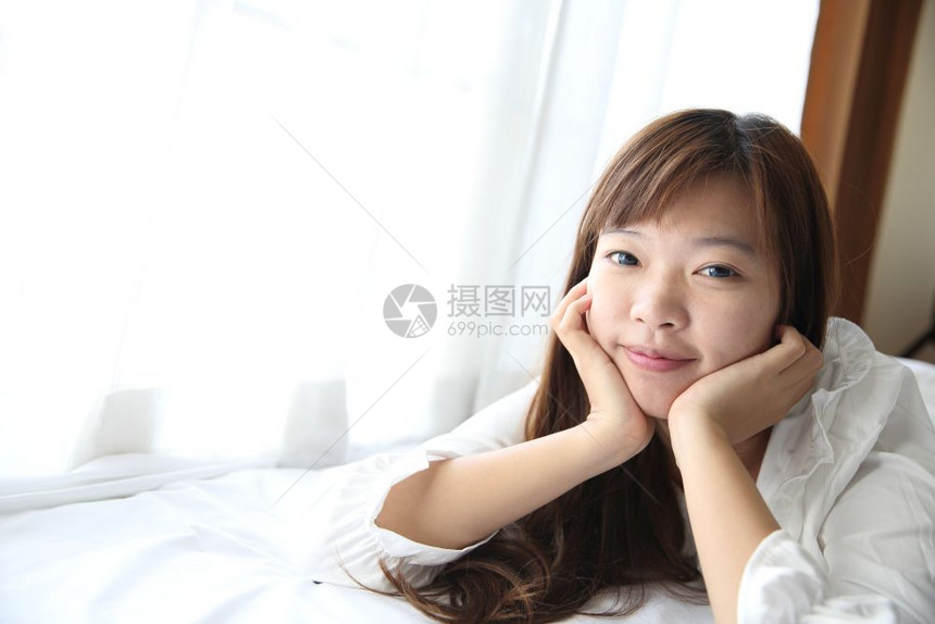 年轻少女躺在洁白的床上图片