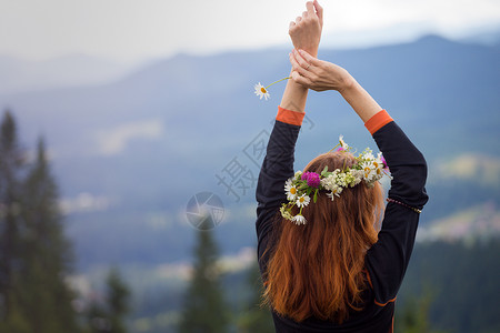 小雏菊花环在山上的野花圈里女孩背景