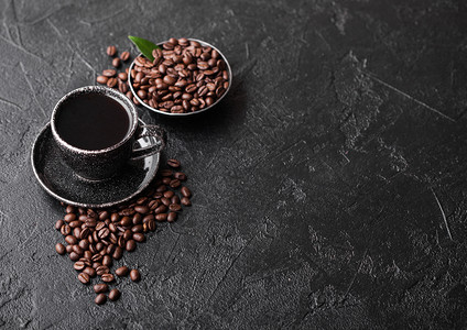 新鲜生有机咖啡豆和树叶黑底咖啡杯图片