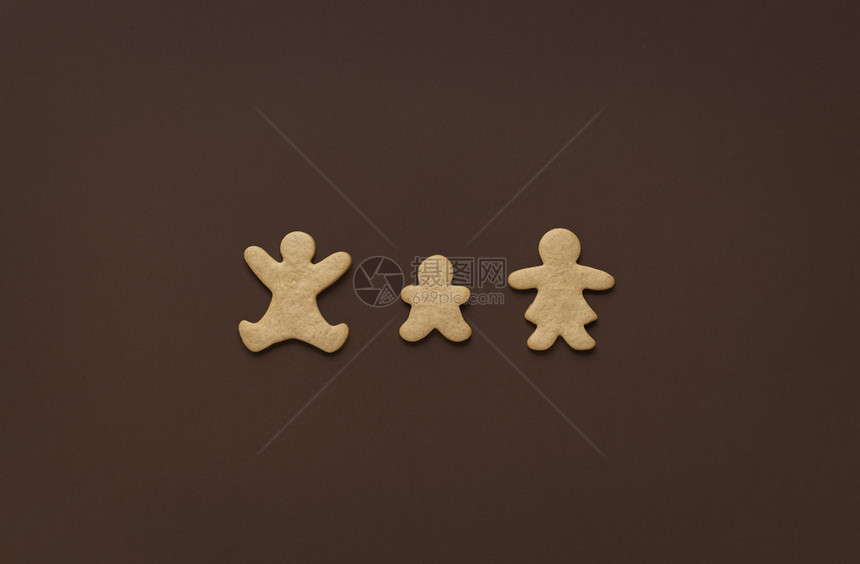 圣诞节概念的家庭姜饼干以父母和孩子的形状最小棕色背景高于圣诞节糖果的视野图片