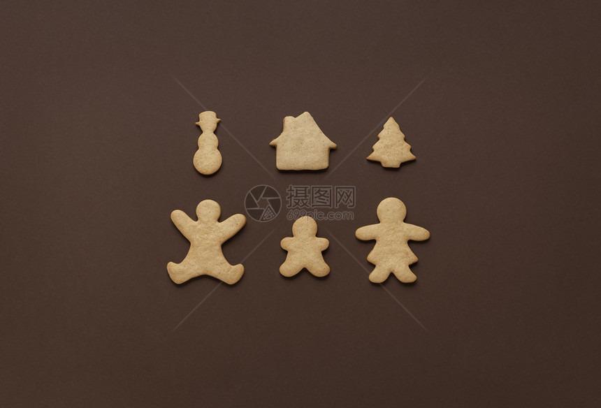 圣诞节作为家庭时间概念以父母和孩子的形式以姜饼干及棕色背景的xma符号传统甜点图片