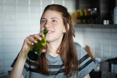 女子在厨房喝啤酒图片