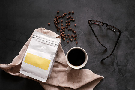 咖啡豆和黑热杯的品牌特征在石头背景商业和模型概念上戴眼镜图片