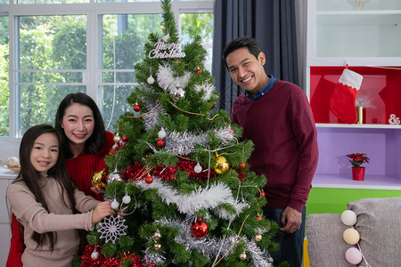 幸福的一家人在装饰圣诞树图片
