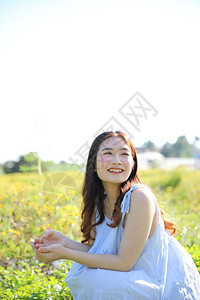 绿色连衣裙年轻女在花园中微笑的肖像背景