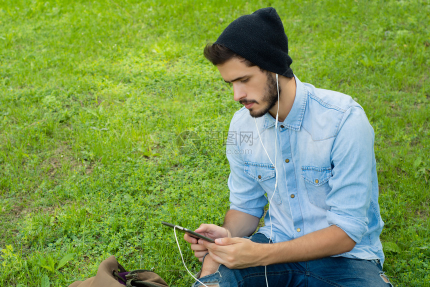 年轻拉丁男子使用智能手机的肖像户外图片