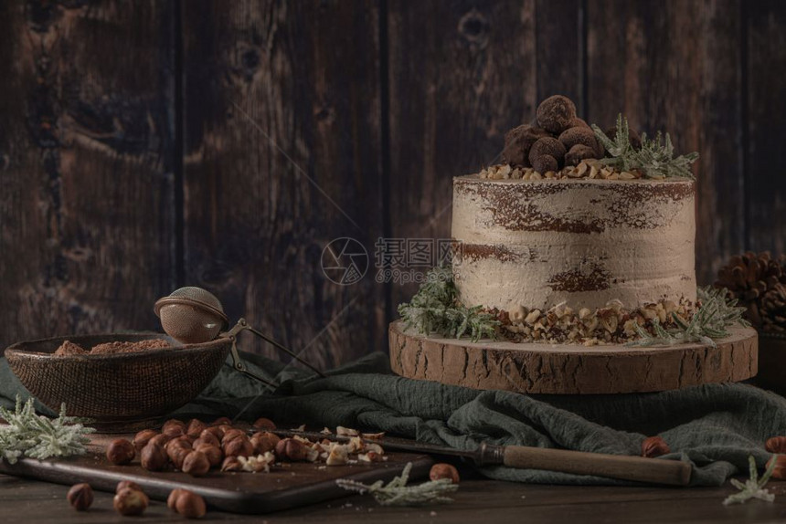 美味的巧克力和栗子蛋糕在餐桌上生锈的木制厨房柜台图片