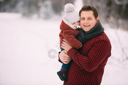 年轻父亲抱着小孩子在雪地里玩耍图片