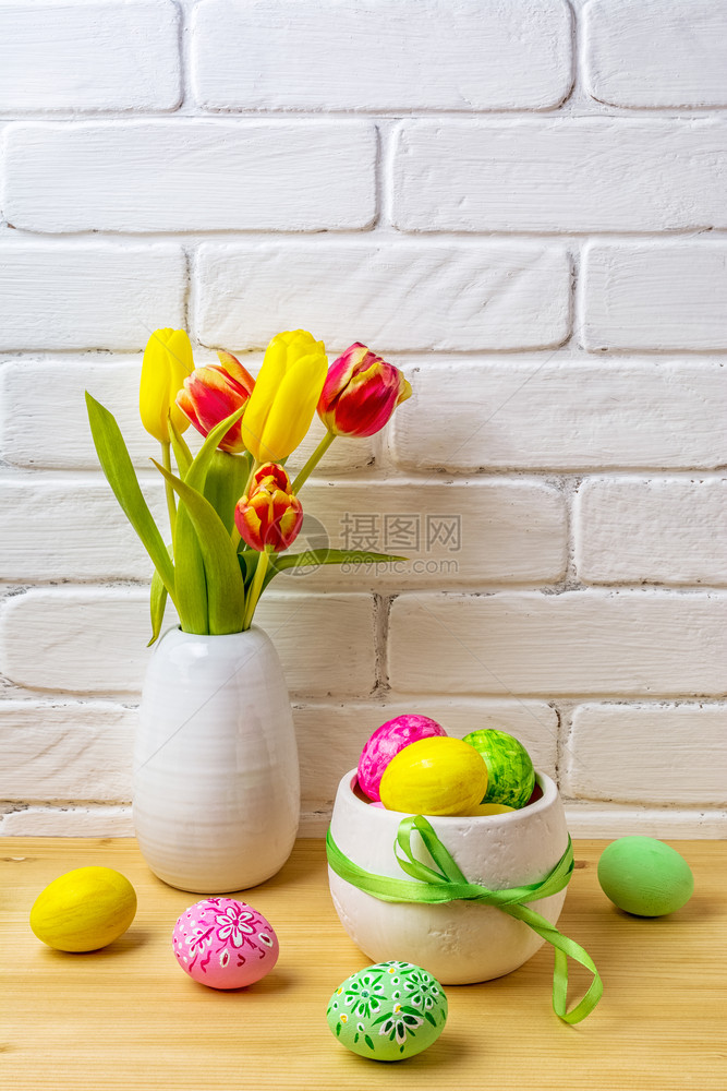 与白花瓶中的粉绿色黄手装饰鸡蛋红色和黄郁金香的东方安排图片