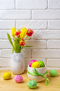 与白花瓶中的粉绿色黄手装饰鸡蛋红色和黄郁金香的东方安排图片