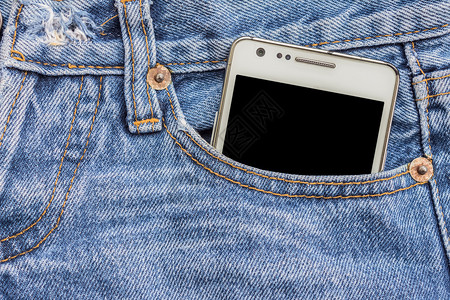 牛仔裤口袋中的白色电话图片