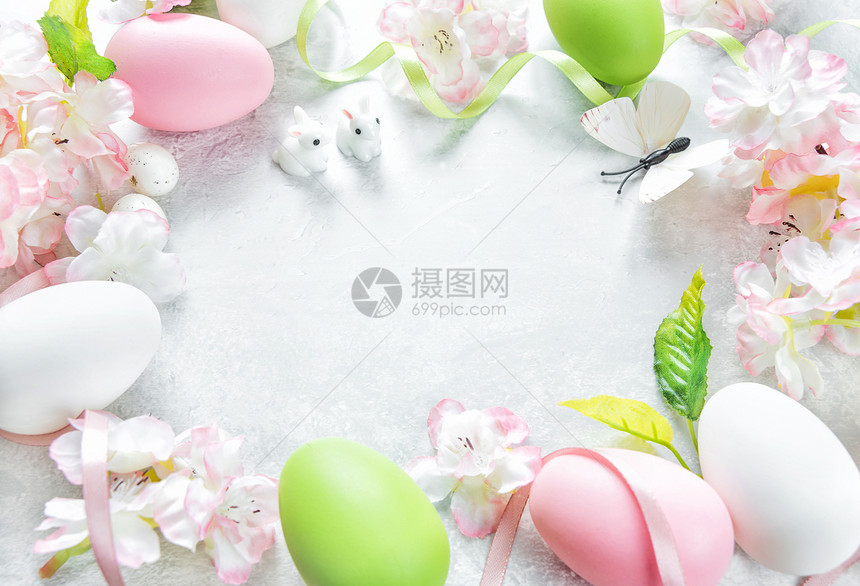 美丽的微妙东边框架有粉红樱花多色的东鸡蛋兔和石头背景上的蝴蝶并有复制空间图片