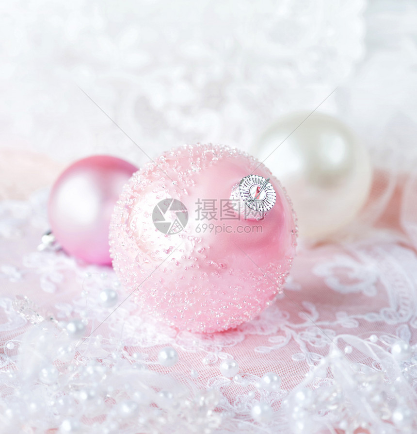 白色和粉颜的美丽圣诞节装饰几个带有白丝和珍珠的圣诞节球在浅薄的彩色背景上带有复制空间的垂直图像图片