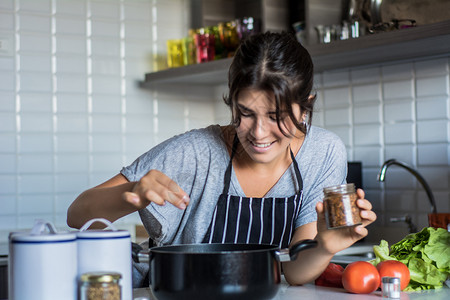 年轻女在家里厨房做饭健康的食物图片