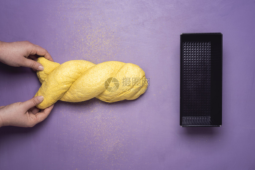 与妇女一起烤玉米面包概念将黄色面团制成玉米包在紫色桌边的玉米面包扁平的自制健康面包土豆图片