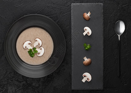 黑餐厅盘子底的奶油栗子辣椒蘑菇汤黑石板和新鲜蘑菇顶级风景图片