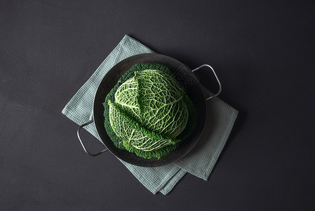 黑背景的厨房毛巾上生锈的铁锅中绿色白菜健康饮食物蓝菜新鲜蔬图片
