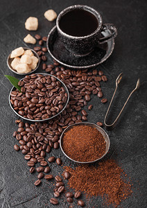 新鲜生有机咖啡茶配豆子和甘蔗糖方块的地面粉末底有咖啡树叶图片