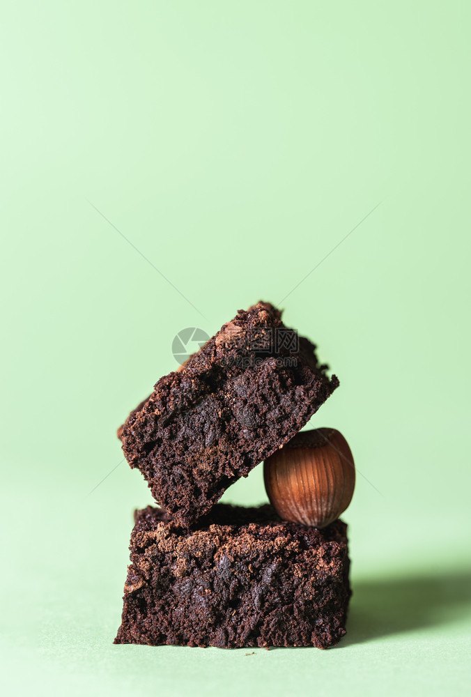 两块深巧克力蛋糕和一块栗子薄荷绿色背景美味的软糖巧克力蛋糕方块可爱的巧克力蛋糕图片